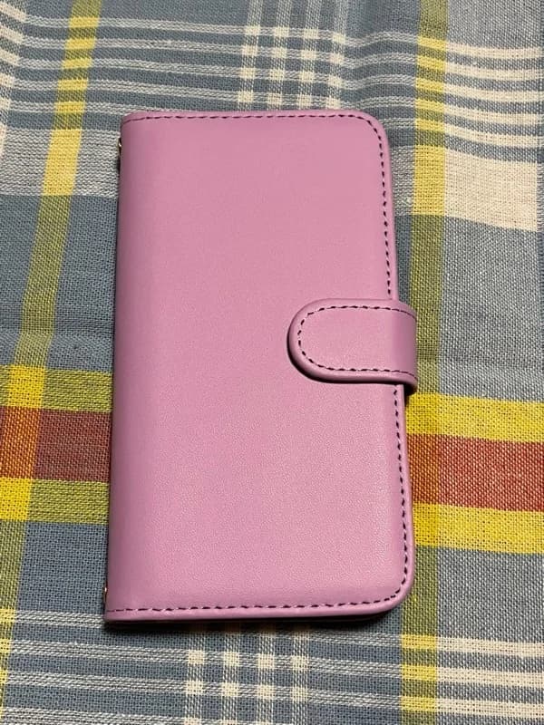 チェック柄の布の上に置かれたピンクのスマホケース