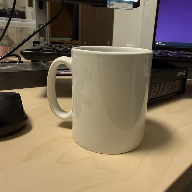 PCデスクの上に置かれた白いマグカップ